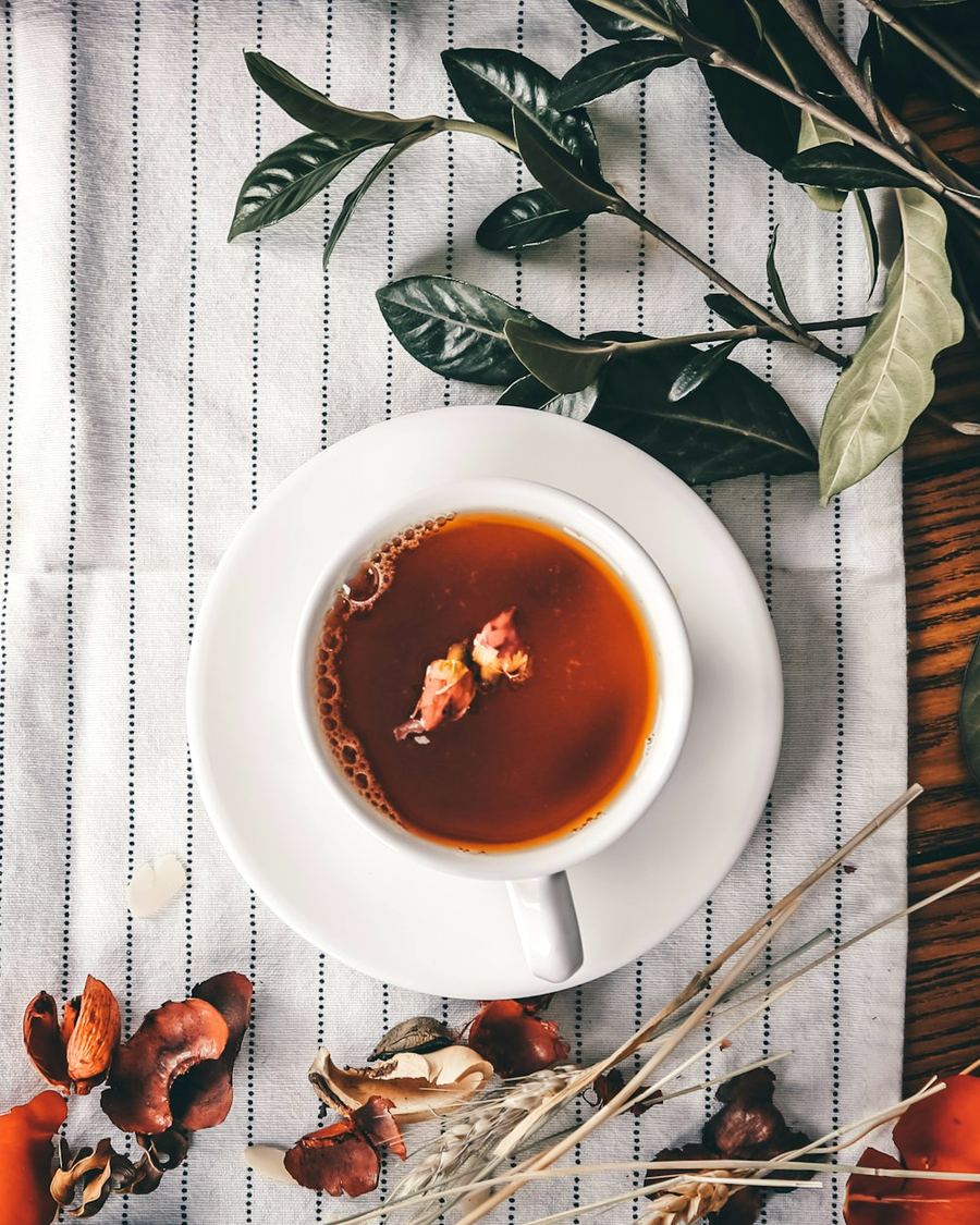 Taza de té sobre un mantel de lino con hojas secas